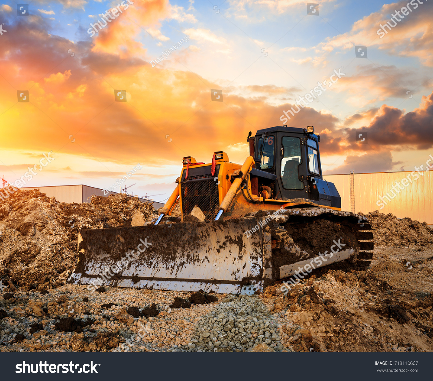 stock-photo-bulldozer-on-a-building-site-at-sunset-718110667.jpg